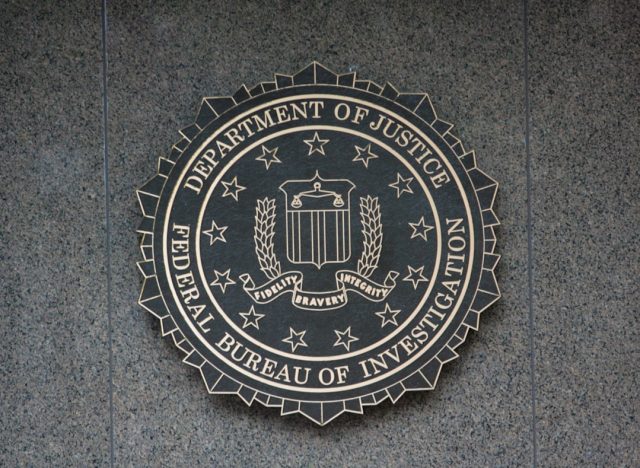 FBI Declassifies 52-Page UFO File Spanning 1947 to 1968 A redacted FBI document titled 62-HQ-83894 with blacked-out text and official stamps on a desk.