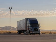 Tesla Sets April 2026 Volume Production for Semi Truck Tesla Semi truck parked at a charging station with Giga Nevada facility in the background