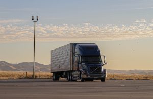 Tesla Sets April 2026 Volume Production for Semi Truck Tesla Semi truck parked at a charging station with Giga Nevada facility in the background