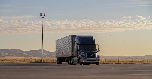 Tesla Sets April 2026 Volume Production Date for Long-Awaited Semi Tesla Semi truck parked at a charging station with Giga Nevada facility in the background