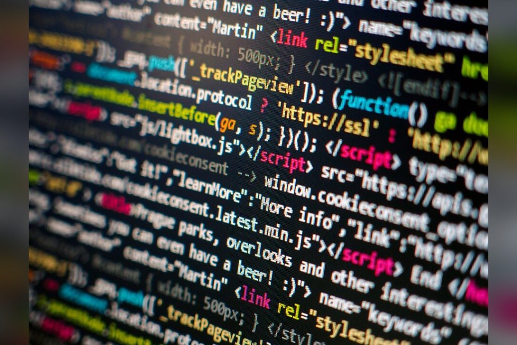 Software Developer At Computer With Code On Screen
